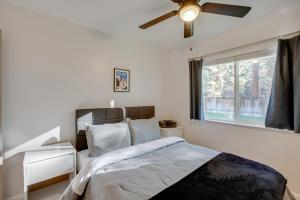 南太浩湖Cozy Lake Tahoe Home with Yard, Near Ski Resorts!的一间卧室配有一张带吊扇和窗户的床。