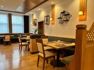 SpaichingenHotel Restaurant Kreuz Spaichingen的用餐室配有木桌和椅子