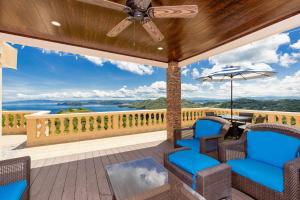 普拉亚埃尔莫萨Casa Q - Bella Vista的观景甲板上配有椅子和遮阳伞的天井