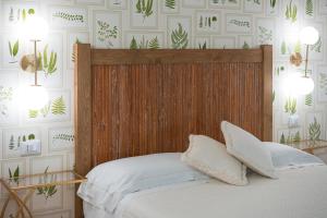 巴尼奥雷焦Acqua di Civita Beauty & Rooms IL PONTE的一间卧室配有一张带木制床头板的床