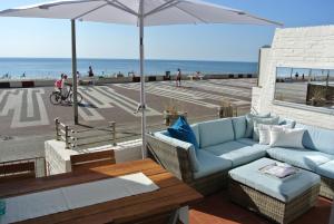 赞德沃特斯特兰笛兹赞德沃特酒店的一个带沙发和遮阳伞的庭院和海滩