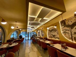 班加罗尔Hotel Le Grandeur的用餐室配有桌椅,墙上挂有绘画作品