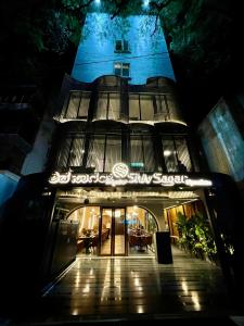 班加罗尔Hotel Le Grandeur的一座建筑,在晚上前方有标志