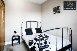 北安普敦Elegant Two Bedroom House by AV Hughes Properties Short Lets & Serviced Accommodation Northampton with Free Parking & Fast Wi-Fi的卧室配有黑白床和桌子