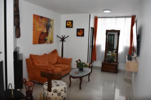 波哥大ApartaHotel Modelia con Parqueadero的客厅配有橙色沙发和桌子