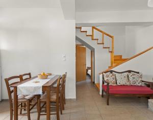 瑞格利亚Maria's Residence的一间带桌椅和楼梯的用餐室