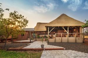 利文斯顿The Nkhosi Livingstone Lodge and Spa的茅草屋顶和庭院的房子