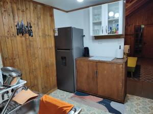 安加罗阿Cabaña Uka Moana的带冰箱和木墙的厨房