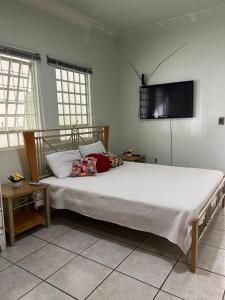 库亚巴Casa 3 suítes no centro de Cuiabá的卧室配有一张大床,墙上配有电视