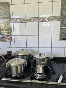 库亚巴Casa 3 suítes no centro de Cuiabá的厨房里的2个炉子和锅