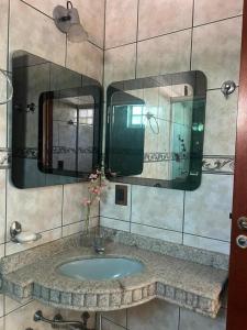 库亚巴Casa 3 suítes no centro de Cuiabá的一间带水槽和两面镜子的浴室