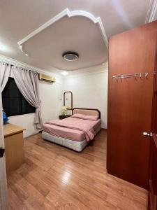 民都鲁Bintulu AirBnB Homestay的一间卧室配有一张床,铺有木地板