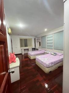 民都鲁Bintulu AirBnB Homestay的铺有木地板的客房内的两张床