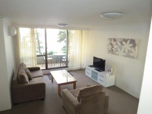 悉尼曼利天堂公寓汽车旅馆的带沙发、电视和桌子的客厅