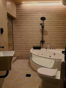 尼兹瓦Alaqur View Inn نزل واجهة العقر的带浴缸、卫生间和盥洗盆的浴室