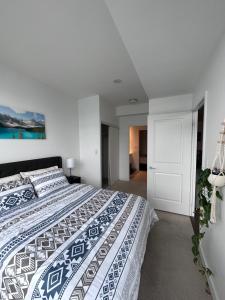 多伦多Stylish 2 Bedrooms Condo w/ awesome View & Parking的一间卧室配有一张带蓝色和白色床单的床。