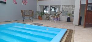 圣卡洛斯-德巴里洛切Nina Hostel的一个带椅子的房间,有一个蓝色的大游泳池