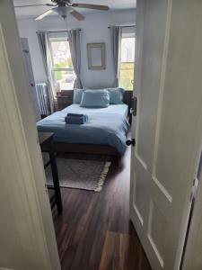 曼切斯特Street side studio apartment的一间卧室配有一张带蓝色枕头的床和吊扇