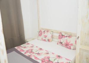 达喀尔Chez Ouly的一间小卧室,配有一张粉红色的鲜花床