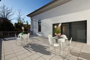 贝加莫吉欧住宿加早餐旅馆的一座带白色椅子和桌子的庭院和一座建筑