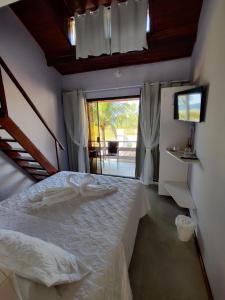 布希奥斯Pousada Sweet Home的卧室配有白色的床和窗户。