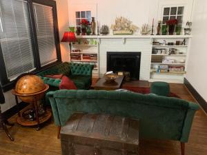 拉法叶Dr. Yaple's Art Deco House的客厅设有2张绿色沙发和壁炉