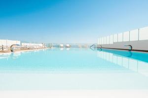 卡斯泰拉马莱Marina di Petrolo Apartments的大楼内的一个蓝色海水游泳池