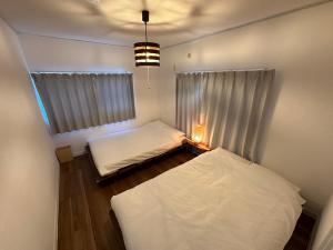 IchigayaShirako House的小房间设有两张床和窗户