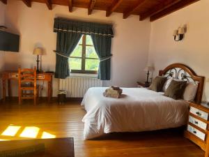 DobresHotel Rural El Sestil的一间卧室配有一张床、一张书桌和一个窗户。