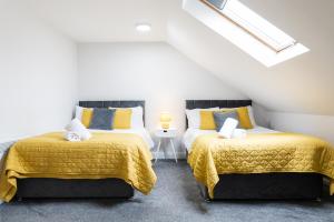 卡迪夫Modern Apartments Near Cardiff City Centre的阁楼间设有两张黄色和蓝色的床