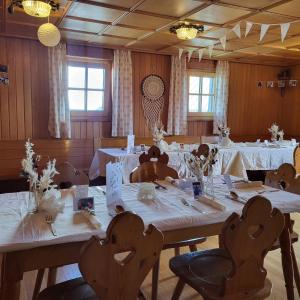 埃本塞Christophorushütte am Feuerkogel的用餐室配有桌椅和白色桌布