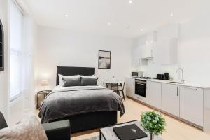伦敦Olympic Park Apartments的一间白色卧室,配有床和厨房