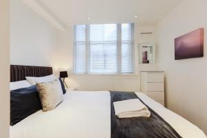 伦敦Olympic Park Apartments的卧室设有一张白色大床和一扇窗户。