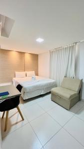 若昂佩索阿Hotel Pousada Kairos Manaira的配有一张床和一把椅子的酒店客房