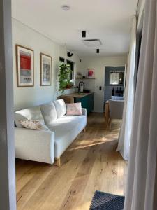 哈嫩克利博克斯维斯Cozy Cabins I Tiny House Seecontainer的一间带白色沙发的客厅和一间厨房