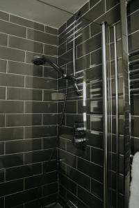 HoltRetreat on the Green的黑色瓷砖浴室内的淋浴