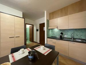 廖卢纳托Residence le Polle的厨房配有桌子、水槽和橱柜。