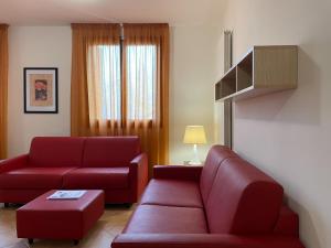 廖卢纳托Residence le Polle的客厅配有红色家具和红色沙发