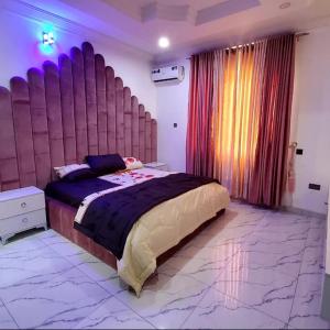 伊巴丹Luxurythemain的一间卧室配有一张大床和大床头板