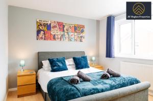 KingsthorpeExclusive Two Bedroom House by AV Hughes Properties Short Lets & Serviced Accommodation Northampton For Families & Business的一间卧室配有一张带蓝色枕头的床