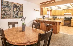 戈尔德比奇Gold Beach Inn的厨房以及带木桌和椅子的用餐室。