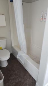 西黄石黄石江山旅馆的带淋浴帘和卫生间的浴室