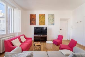 罗马Fisher's Apartment in Testaccio的客厅配有2把红色椅子和电视