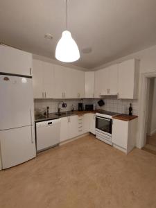 斯德哥尔摩Home Inn MRT19的一间空厨房,配有白色的橱柜和灯具