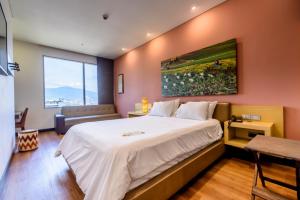 麦德林哥伦比亚十级酒店 的卧室设有一张白色大床和一扇窗户。