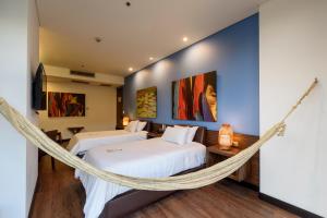麦德林哥伦比亚十级酒店 的带吊床的客房内的两张床