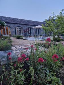 德罗赫达The Garden Rooms at The Courtyard,Townley Hall的一座花园,在房子前方种有粉红色的花朵