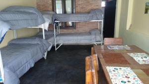 波特雷罗德洛斯弗内斯Hostel el Tata的客房设有三张双层床和一张桌子。