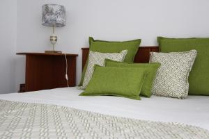 卡斯卡伊斯ARRUDA LUXURY APARTMENT with AC的一张带绿色和白色枕头的床和一盏灯