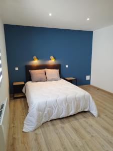FraizeGîte l'harmonie I的一间卧室配有一张白色大床和蓝色的墙壁